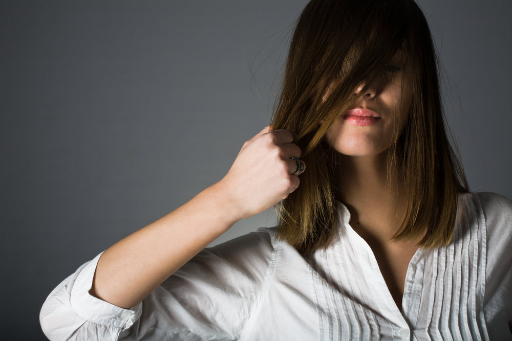 Woman with straight brown hair illustrating hair thickening products for fuller-looking hair.