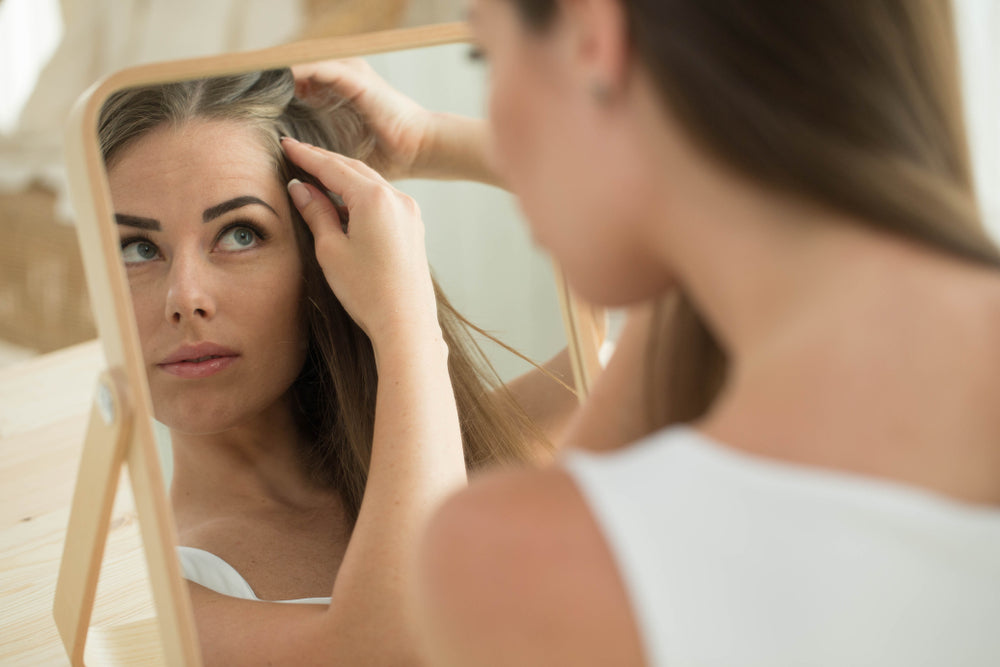 Woman analysing scalp in mirror